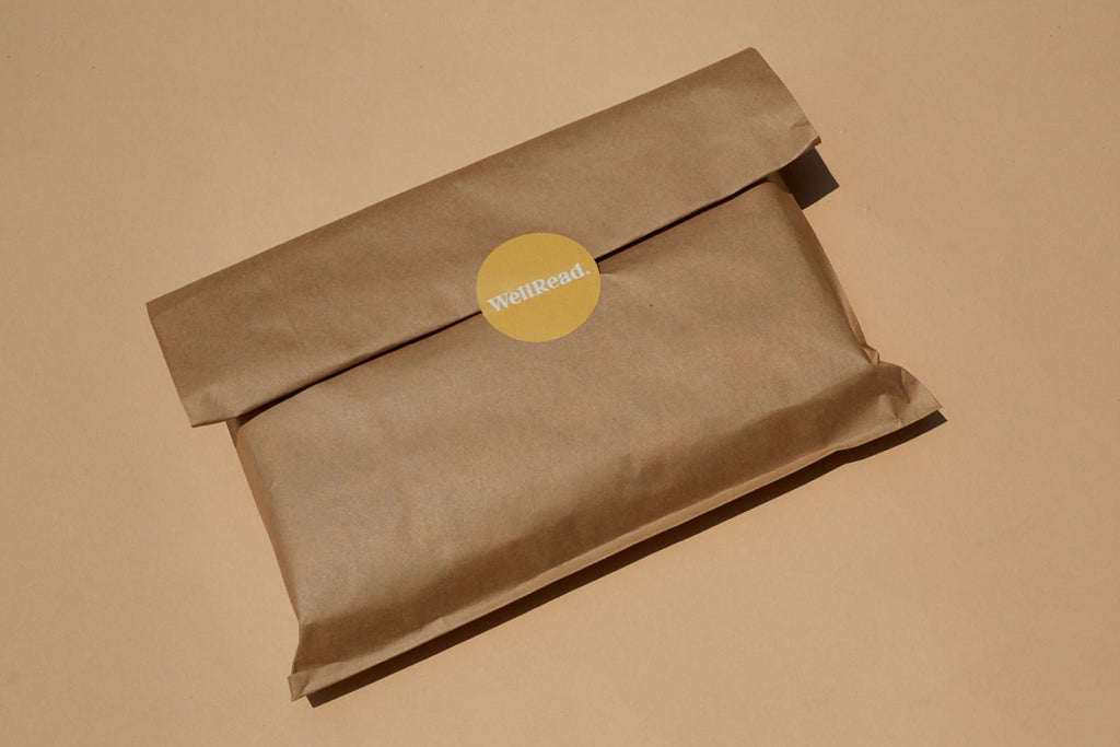 Brown paper package with a WellRead yellow label on a beige background