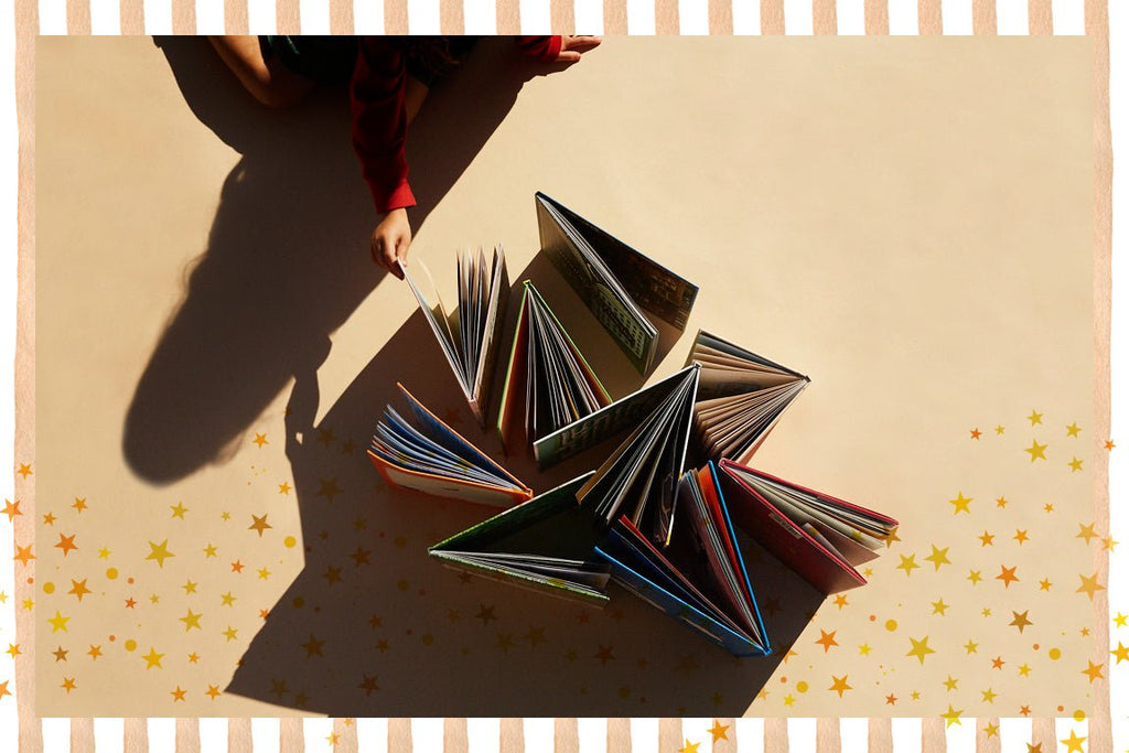 Stack of open books on a textured surface with star patterns