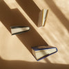 Three books of different sizes on a beige surface with shadows